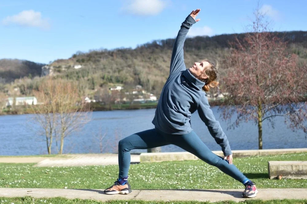 Lydie en posture de yoga au bord de l'eau.